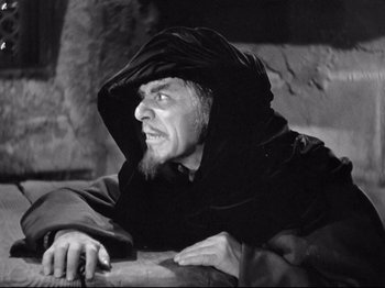 Movie still from “If I Were King” (1938), directed by Frank Lloyd – An old man with a beard wearing a black robe; Medium shot, Over the shoulder angle