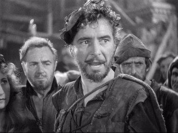 Movie still from “If I Were King” (1938), directed by Frank Lloyd – A black - and - white photo of a man with a beard; Medium shot, Over the shoulder angle