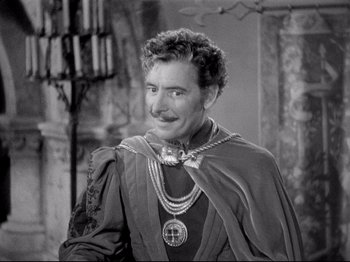 Movie still from “If I Were King” (1938), directed by Frank Lloyd – A man in a medieval costume is smiling for the camera; Medium shot, High angle
