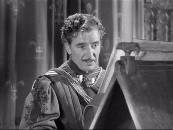 Movie still from “If I Were King” (1938), directed by Frank Lloyd – An older man is looking at a piece of art; Close Up shot, High angle