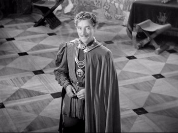 Movie still from “If I Were King” (1938), directed by Frank Lloyd – A man dressed in medieval clothing standing on a tiled floor; Wide shot, High angle
