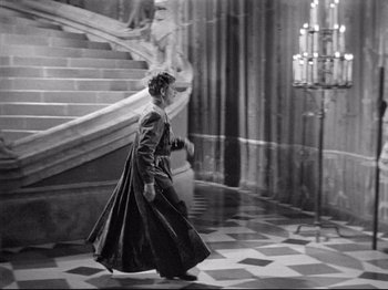 Movie still from “If I Were King” (1938), directed by Frank Lloyd – A woman walking down the stairs of a building; Wide shot, High angle