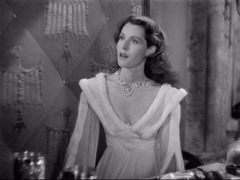 Movie still from “If I Were King” (1938), directed by Frank Lloyd – A black and white photo of a woman in a dress; Medium shot, Over the shoulder angle