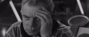 Movie still from “Voyage to the End of the Universe” (1963), directed by Jindrich Polák – An older man is holding his hand to his head; Close Up shot, High angle
