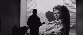 Movie still from “Voyage to the End of the Universe” (1963), directed by Jindrich Polák – A man and a woman are standing in front of a window; Medium shot, Low angle