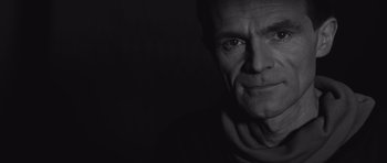 Movie still from “Voyage to the End of the Universe” (1963), directed by Jindrich Polák – Black and white photograph of a man with a scarf around his neck; Close Up shot, Low angle