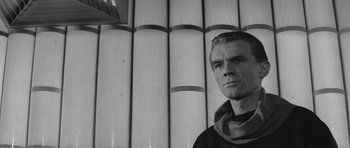 Movie still from “Voyage to the End of the Universe” (1963), directed by Jindrich Polák – Black and white photograph of a man in front of a wall; Close Up shot, Low angle