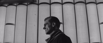 Movie still from “Voyage to the End of the Universe” (1963), directed by Jindrich Polák – Black and white photograph of a man in front of a wall; Medium shot, Low angle