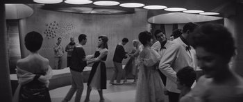 Movie still from “Voyage to the End of the Universe” (1963), directed by Jindrich Polák – A black and white photo of people dancing in a room; Wide shot, Low angle