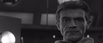 Movie still from “Voyage to the End of the Universe” (1963), directed by Jindrich Polák – Black and white photograph of a man's face in front of a window; Close Up shot, Low angle