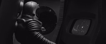 Movie still from “Voyage to the End of the Universe” (1963), directed by Jindrich Polák – A black and white photo of a person in a spacesuit; Medium shot, High angle
