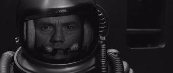 Movie still from “Voyage to the End of the Universe” (1963), directed by Jindrich Polák – A black and white photo of a man in a space suit; Close Up shot, Overhead angle