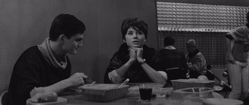 Movie still from “Voyage to the End of the Universe” (1963), directed by Jindrich Polák – A man sitting at a table with another man in front of him; Medium shot, High angle