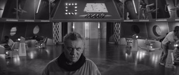 Movie still from “Voyage to the End of the Universe” (1963), directed by Jindrich Polák – An older man standing in front of a building; Medium shot, Low angle