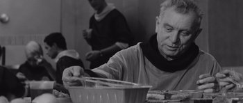 Movie still from “Voyage to the End of the Universe” (1963), directed by Jindrich Polák – An older man sitting at a table with a bowl of food in front of him; Close Up shot, Over the shoulder angle