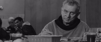Movie still from “Voyage to the End of the Universe” (1963), directed by Jindrich Polák – An older man sitting in front of a bowl; Close Up shot, Over the shoulder angle
