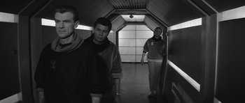 Movie still from “Voyage to the End of the Universe” (1963), directed by Jindrich Polák – A man and a woman are walking down a hallway; Medium shot, Low angle