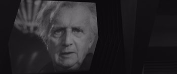 Movie still from “Voyage to the End of the Universe” (1963), directed by Jindrich Polák – An old woman's face is projected on a screen; Close Up shot, Over the shoulder angle