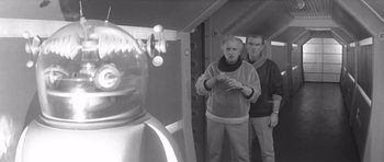 Movie still from “Voyage to the End of the Universe” (1963), directed by Jindrich Polák – Two men standing in front of a mirror; Medium shot, Over the shoulder angle