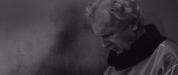 Movie still from “Voyage to the End of the Universe” (1963), directed by Jindrich Polák – An older man with a beard and a neck brace; Close Up shot, Low angle