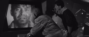 Movie still from “Voyage to the End of the Universe” (1963), directed by Jindrich Polák – Two men are playing a video game in a room; Close Up shot, Over the shoulder angle