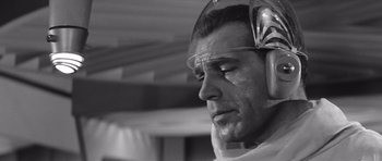 Movie still from “Voyage to the End of the Universe” (1963), directed by Jindrich Polák – Black and white photograph of a man wearing ear muffs; Close Up shot, Low angle