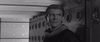 Movie still from “Voyage to the End of the Universe” (1963), directed by Jindrich Polák – Black and white photograph of a man with a scarf around his neck; Close Up shot, Low angle