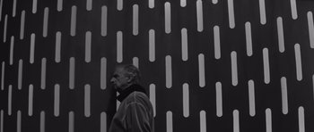 Movie still from “Voyage to the End of the Universe” (1963), directed by Jindrich Polák – A black and white photo of a man in front of a wall; Medium shot, Low angle