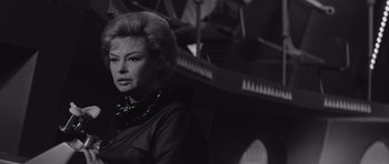Movie still from “Voyage to the End of the Universe” (1963), directed by Jindrich Polák – A black and white photo of a woman in a black dress; Close Up shot, Low angle