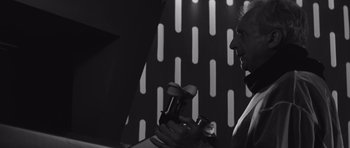 Movie still from “Voyage to the End of the Universe” (1963), directed by Jindrich Polák – A black and white photo of a man holding a pair of dumbbells; Close Up shot, Low angle