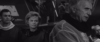 Movie still from “Voyage to the End of the Universe” (1963), directed by Jindrich Polák – A black - and - white photo of a woman and a man; Close Up shot, Over the shoulder angle