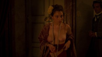 Movie still from “The Bohemian” (2022), directed by Petr Václav – A woman with a flower in her hair is holding pearls; Medium shot, High angle