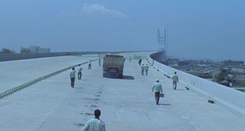 Movie still from “Il Mare” (2000), directed by Hyun-seung Lee – A group of people walking down a road; Extreme Wide shot, High angle