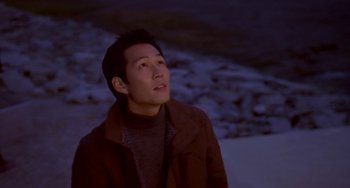 Movie still from “Il Mare” (2000), directed by Hyun-seung Lee – A man in a brown jacket looking up at the sky; Close Up shot, Low angle