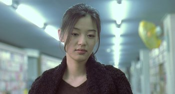 Movie still from “Il Mare” (2000), directed by Hyun-seung Lee – A young asian woman in a black sweater; Close Up shot, Over the shoulder angle