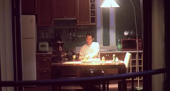Movie still from “Il Mare” (2000), directed by Hyun-seung Lee – A man sitting at a table in a kitchen; Wide shot, High angle