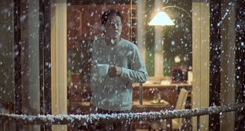 Movie still from “Il Mare” (2000), directed by Hyun-seung Lee – A man standing in front of a window holding a wii controller; Medium shot, Low angle