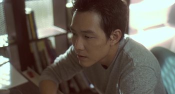 Movie still from “Il Mare” (2000), directed by Hyun-seung Lee – A man sitting in front of a book shelf; Close Up shot, High angle
