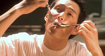 Movie still from “Il Mare” (2000), directed by Hyun-seung Lee – A man with a knife and fork in his mouth; Extreme Close Up shot, High angle