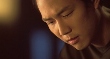 Movie still from “Il Mare” (2000), directed by Hyun-seung Lee – A man's face in a dark room; Close Up shot, Low angle