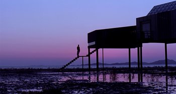 Movie still from “Il Mare” (2000), directed by Hyun-seung Lee – A person standing on a set of stairs in the water; Extreme Wide shot, Low angle