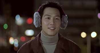 Movie still from “Il Mare” (2000), directed by Hyun-seung Lee – A man wearing ear muffs while wearing a brown jacket; Close Up shot, Low angle