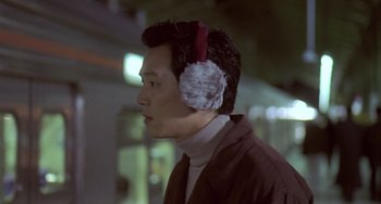 Movie still from “Il Mare” (2000), directed by Hyun-seung Lee – A man wearing ear muffs while standing outside; Close Up shot, Over the shoulder angle
