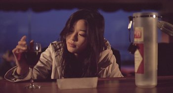Movie still from “Il Mare” (2000), directed by Hyun-seung Lee – A woman sitting at a table looking down at a paper; Close Up shot, Low angle