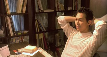 Movie still from “Il Mare” (2000), directed by Hyun-seung Lee – A man sitting in front of a book in a library; Close Up shot, Low angle