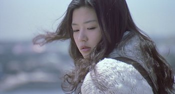Movie still from “Il Mare” (2000), directed by Hyun-seung Lee – A woman with long black hair blowing in the wind; Close Up shot, Low angle