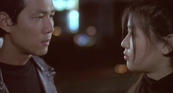 Movie still from “Il Mare” (2000), directed by Hyun-seung Lee – A man and a woman face to face in front of lights; Close Up shot, Over the shoulder angle