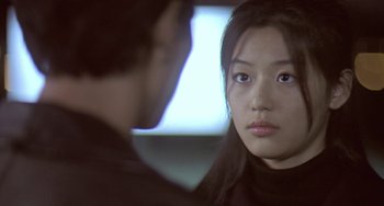 Movie still from “Il Mare” (2000), directed by Hyun-seung Lee – A young asian woman looking at a young man; Close Up shot, Over the shoulder angle