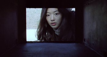 Movie still from “Il Mare” (2000), directed by Hyun-seung Lee – A woman is looking at the camera through a window; Close Up shot, Low angle
