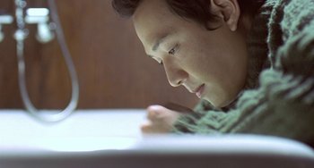 Movie still from “Il Mare” (2000), directed by Hyun-seung Lee – A man is writing on a piece of paper; Close Up shot, High angle